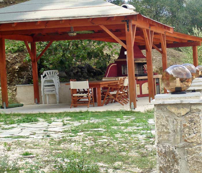 Patio under a pergola with barbecue